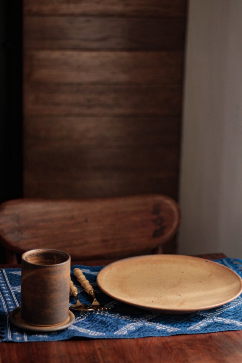A cup and a plate left where they were set down. Handmade Philippine stoneware by AWIS in everyday use.