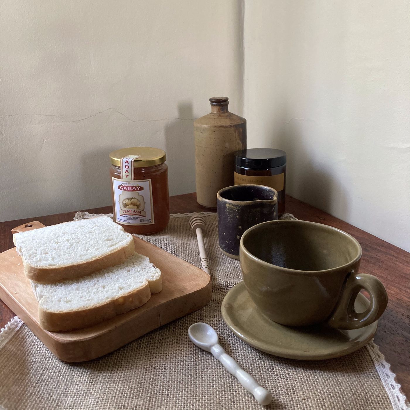 A cappuccino cup and creamer on a dark surface