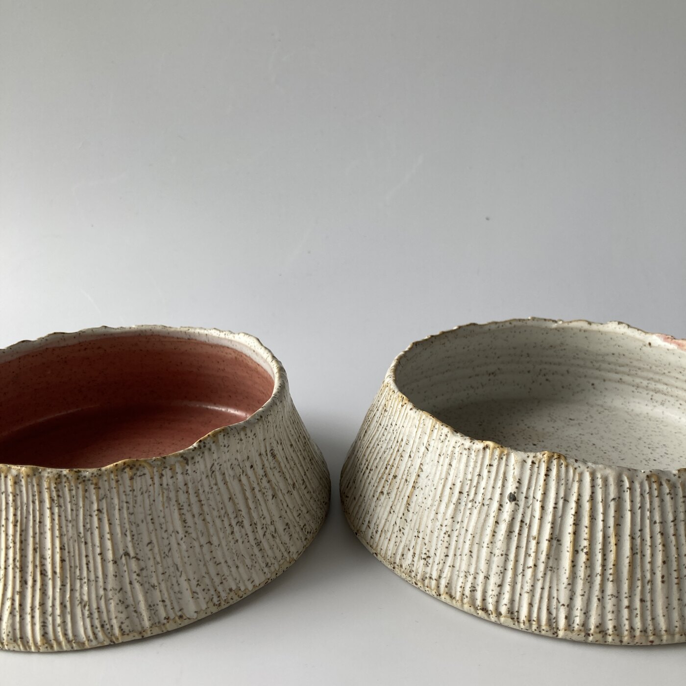 A pair of barnacle bowls, coral and pale, handmade Philippine stoneware