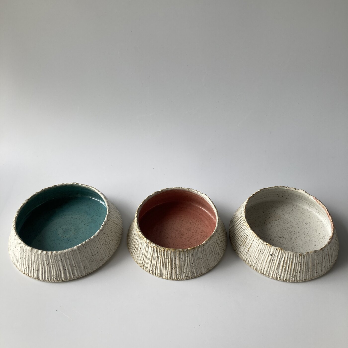 Three small barnacle bowls in bamboo, coral and unglazed stoneware