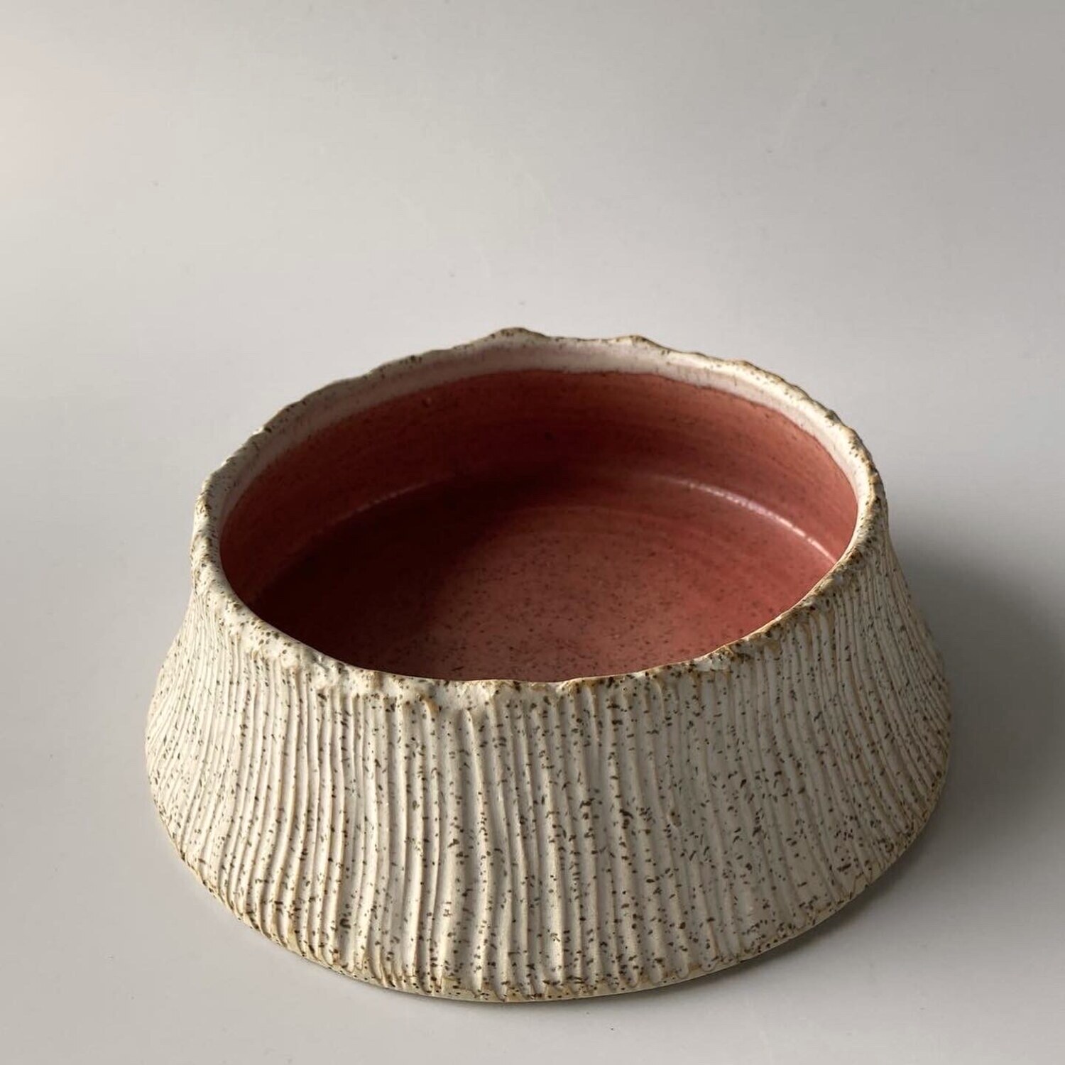 A ridged handmade stoneware bowl with a coral glaze interior, Philippine pottery by AWIS